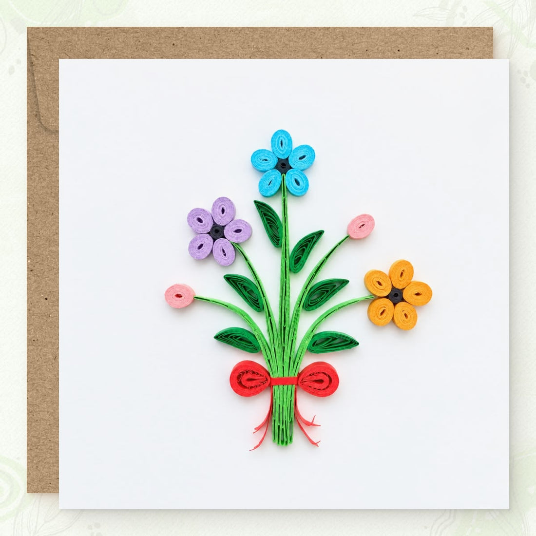 Bouquet quilled greeting card with blue, purple, and orange paper flowers on green stems tied with a red bow.