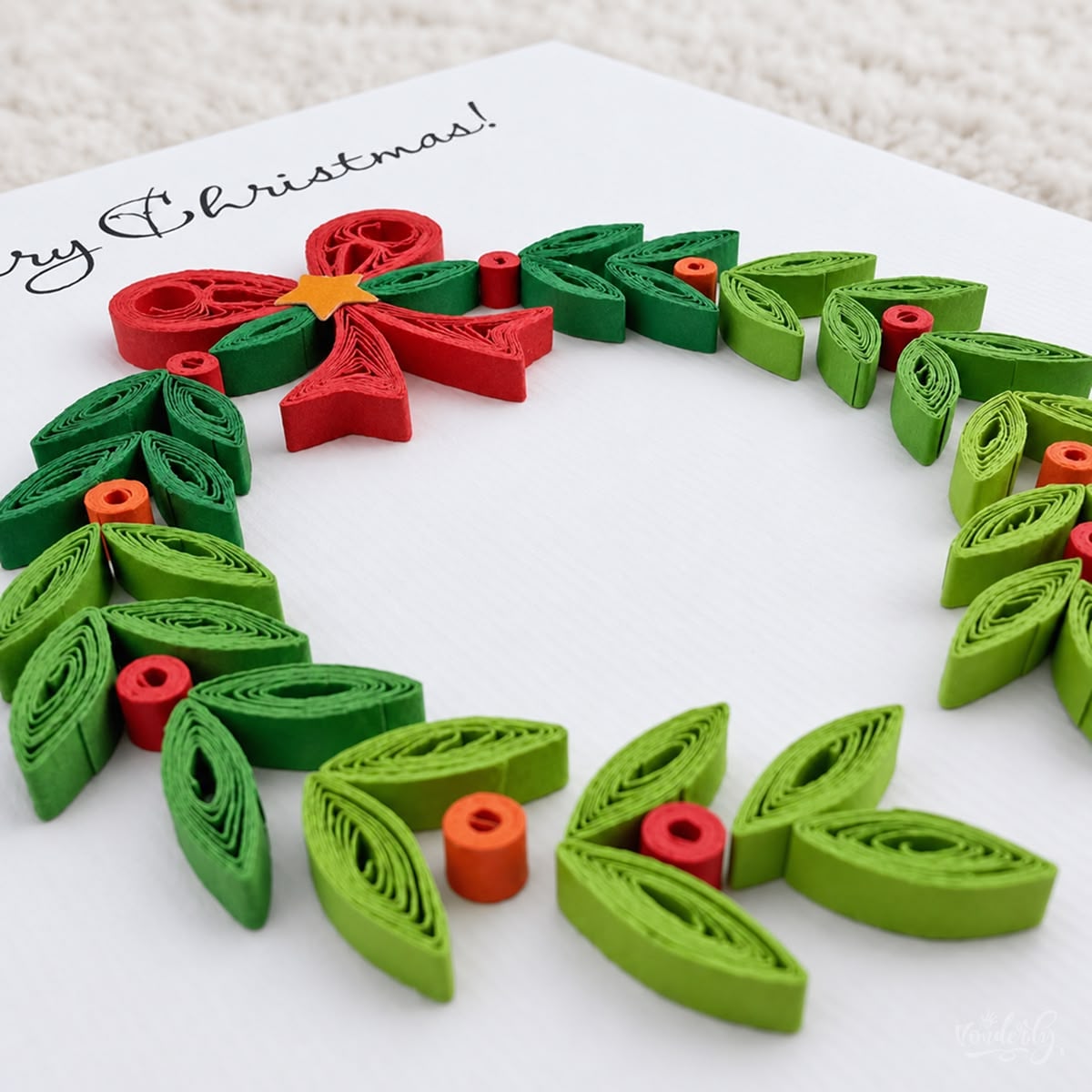 Angled view of the Christmas Wreath card showing the raised green leaves and coiled berries.
