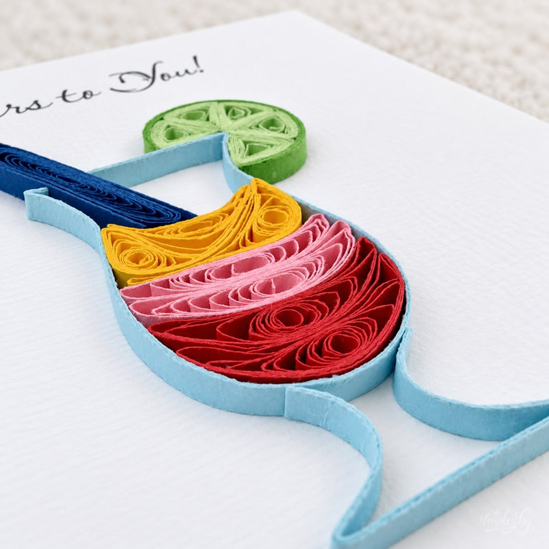 Quilled greeting card with a layered paper drink in a tall glass, a navy stick, and a green lime wheel.