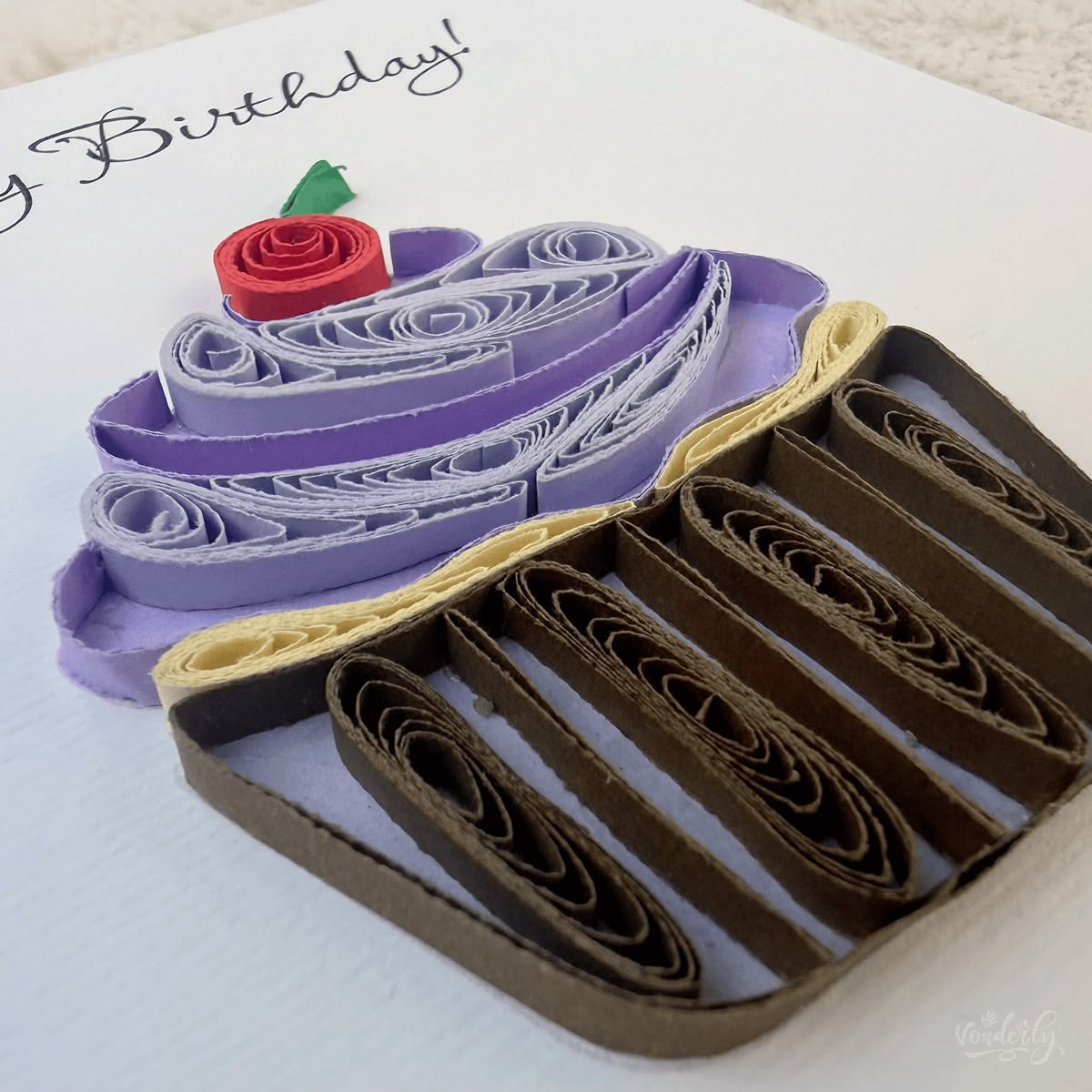 Angled view of quilled cupcake birthday card showing 3D raised paper art, the frosting swirl and coiled wrapper standing off the card surface