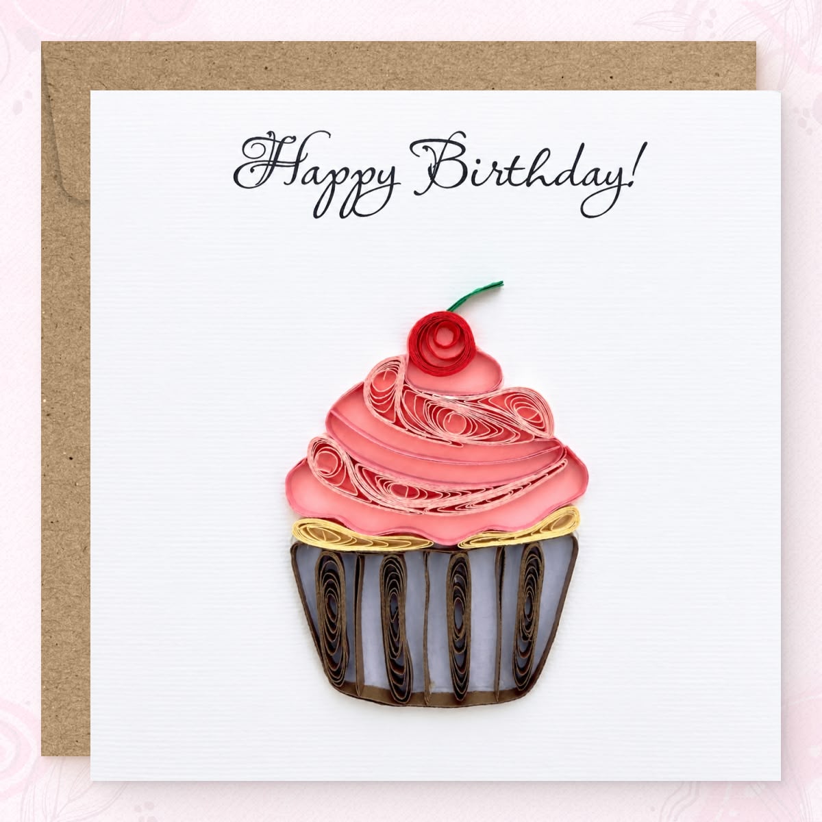 Quilled birthday card with a pink paper frosting swirl, red cherry, and striped wrapper.