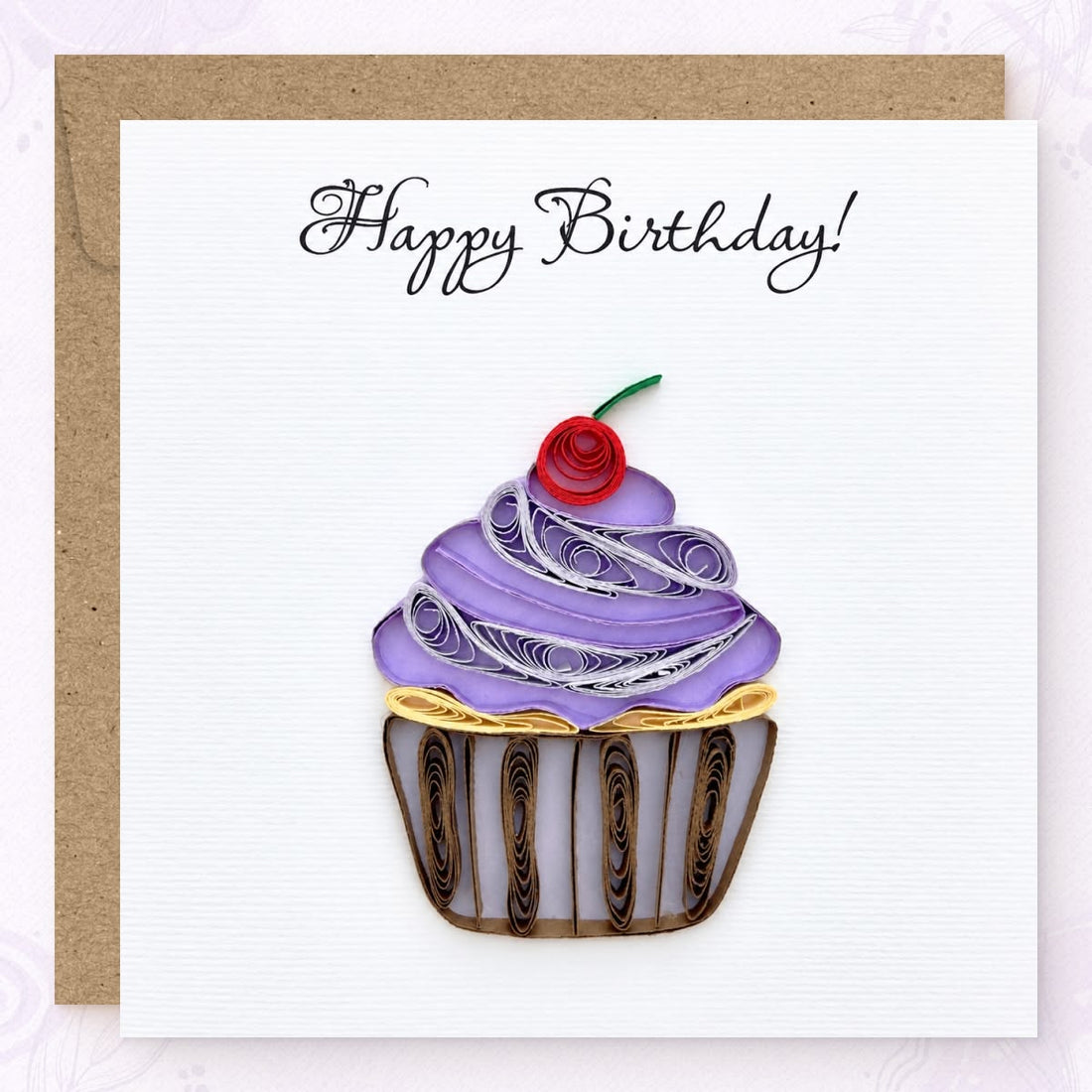 Quilled birthday card with a purple paper frosting swirl, red cherry, and striped wrapper.