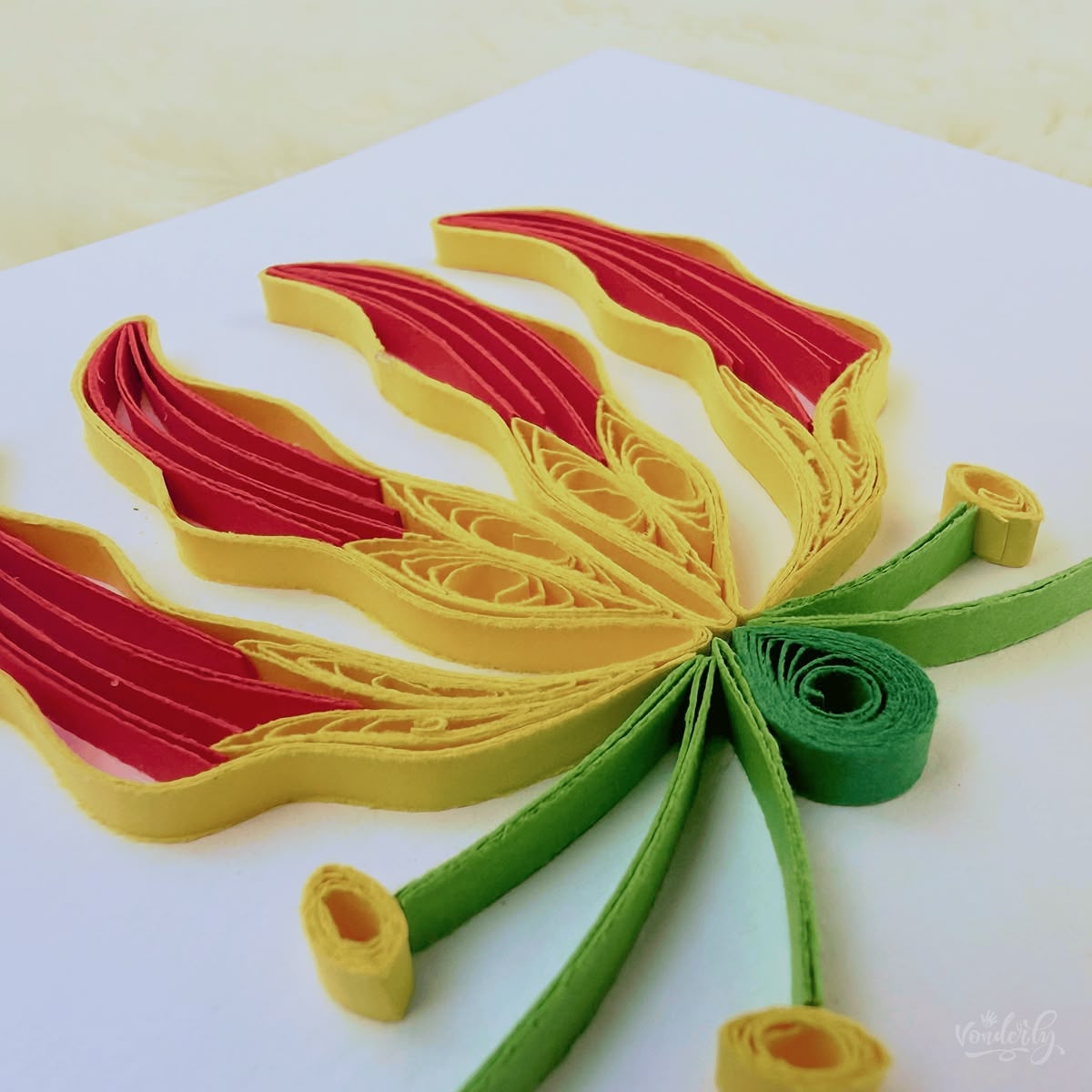 Angled view of quilled flame lily card showing 3D raised paper art, layered petals and central paisley stamen detail visible
