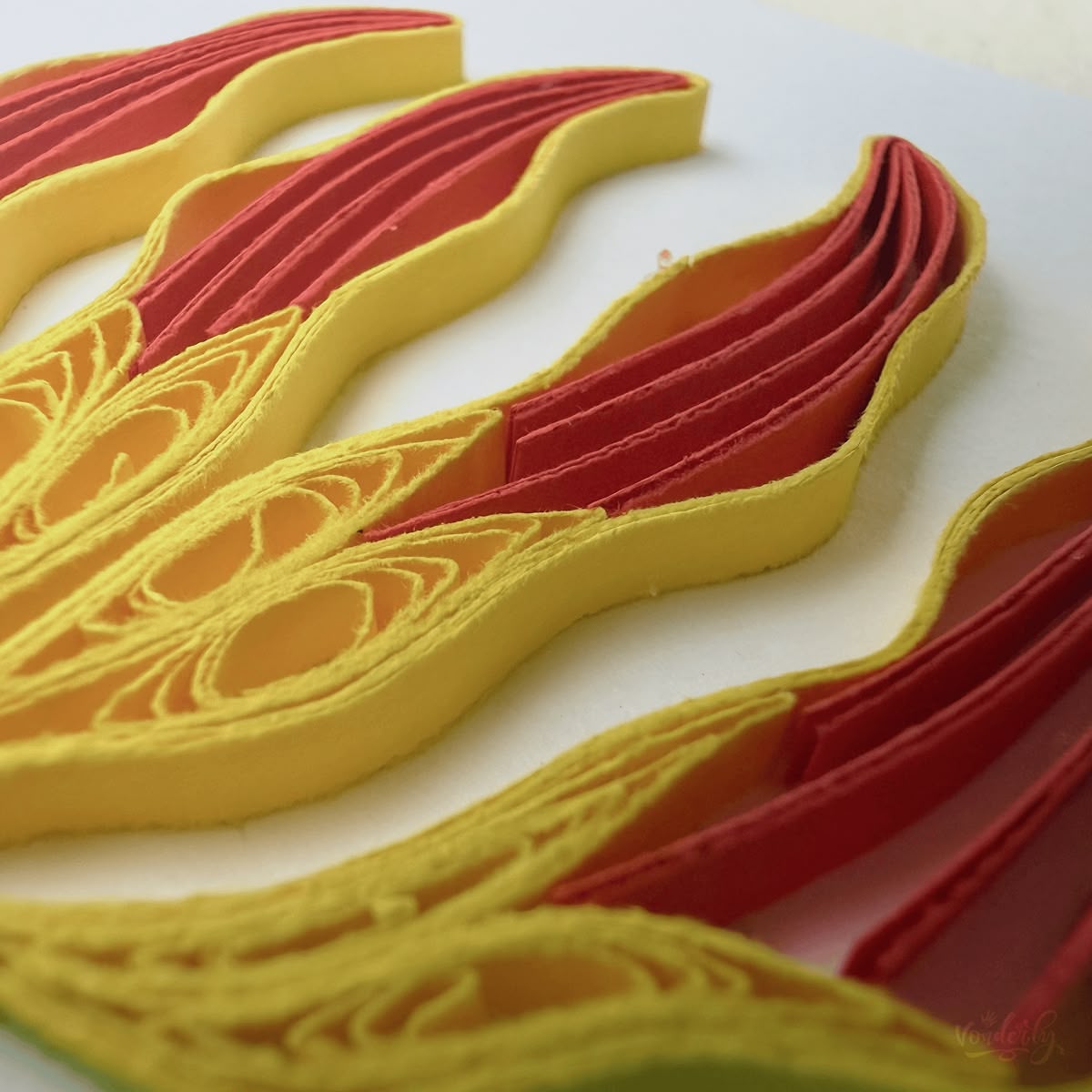 Close-up macro of paper quilling on flame lily card, two-layer petals with yellow edging and intricate yellow stamen coils visible