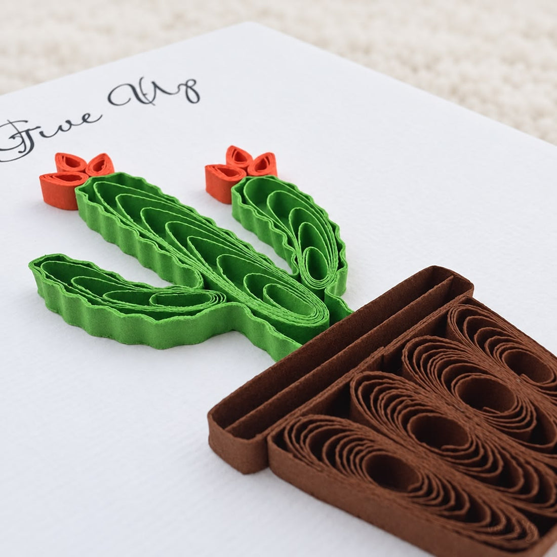 Flowering Cactus quilled greeting card with a green paper cactus, two orange blooms, and a brown pot, printed "Never Give Up" above.