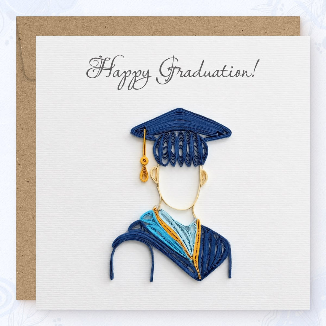 Quilled graduation card with a figure in a navy cap and gown and a navy, sky blue, and gold hood.