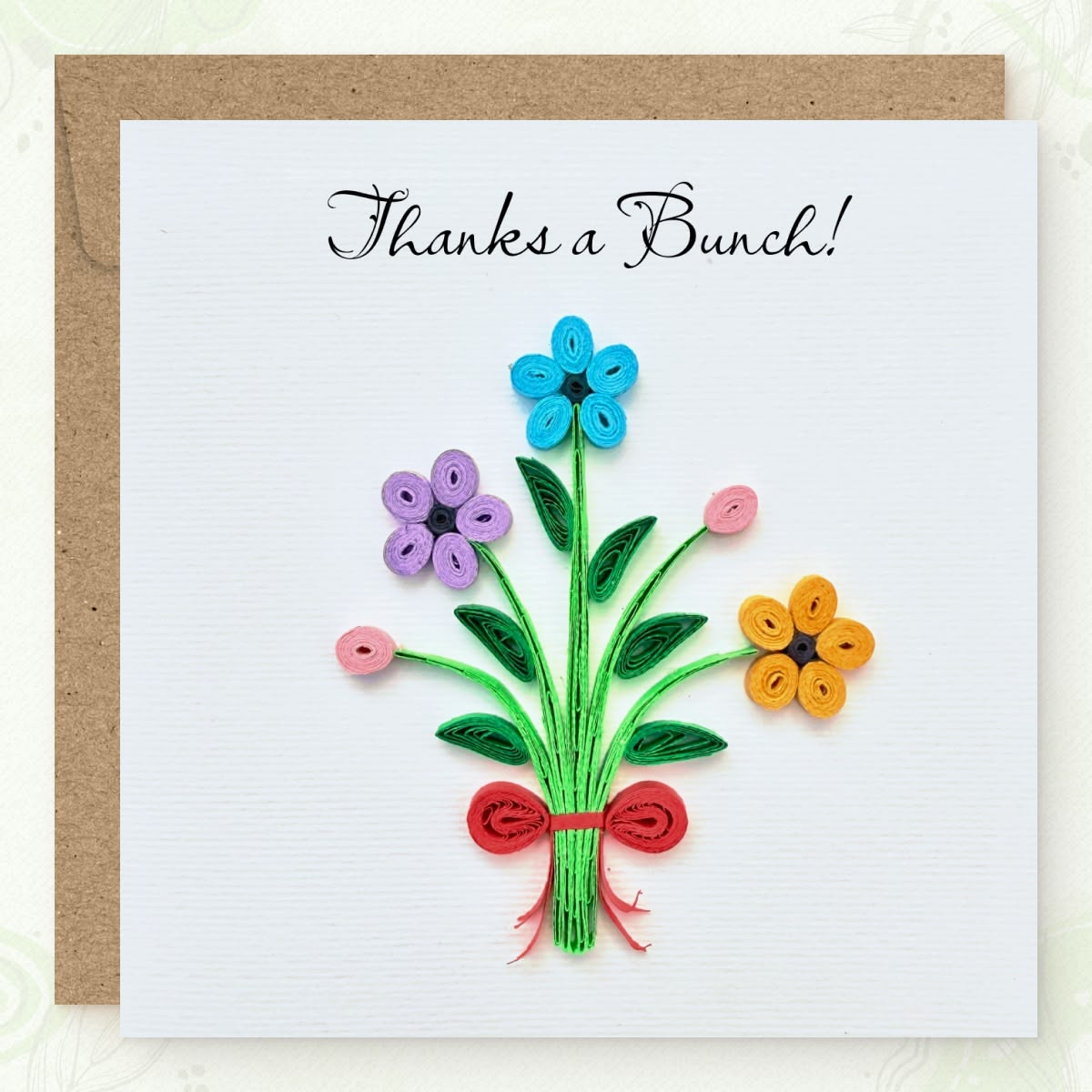 Handmade quilled thank you greeting card with three flowers (blue, lavender, orange), two pink buds, and a red ribbon bow on gathered green stems, "Thanks a Bunch" printed in calligraphic script, paper art by Vonderly