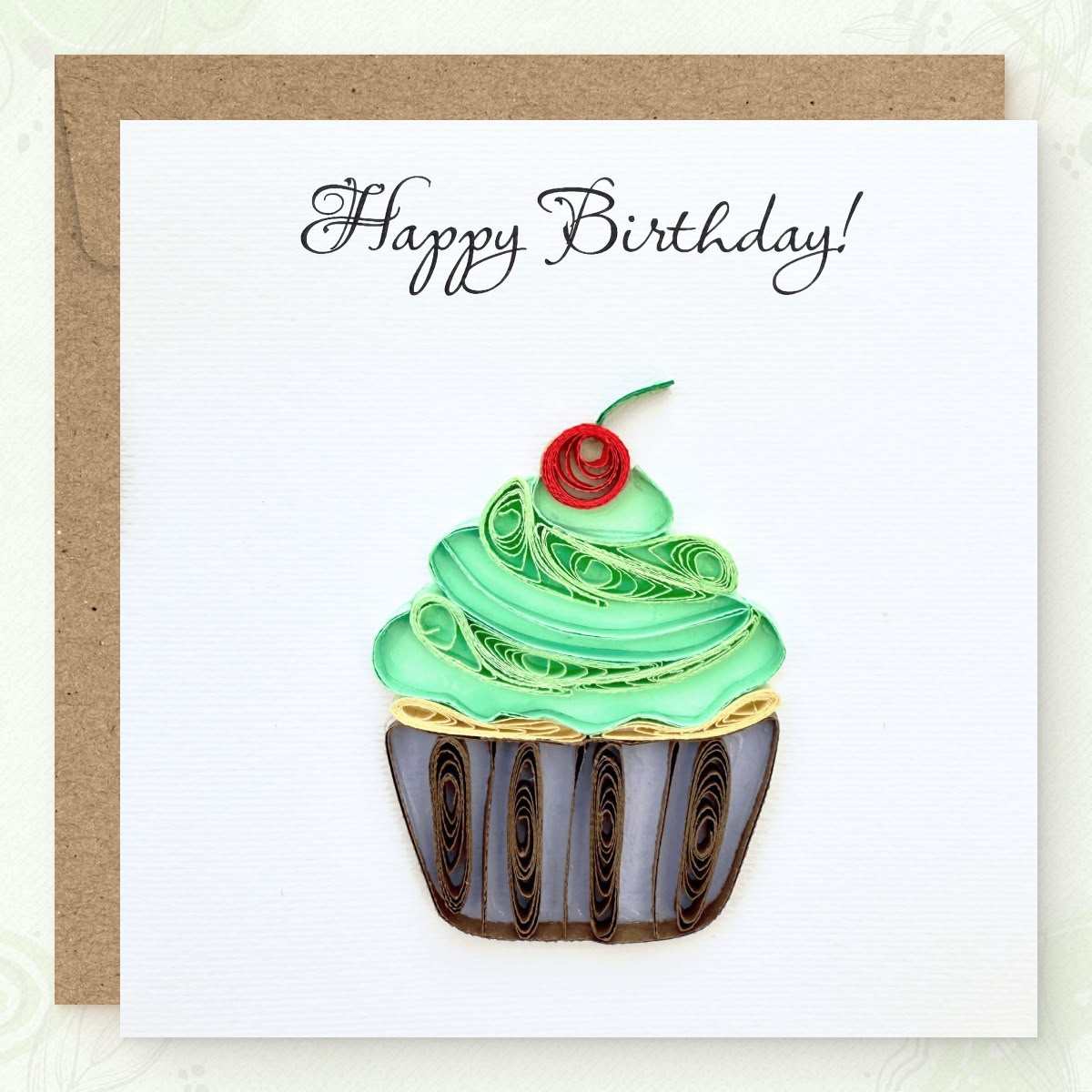 Handmade quilled birthday greeting card with a green frosting cupcake, red cherry, and striped wrapper, "Happy Birthday" in calligraphic script, paper art by Vonderly