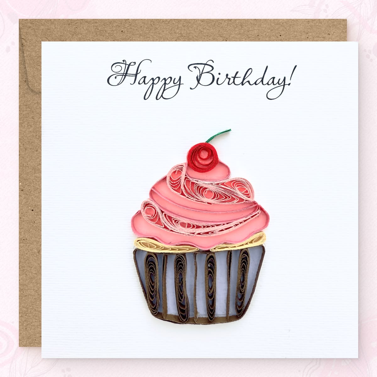 Handmade quilled birthday greeting card with a pink frosting cupcake, red cherry, and striped wrapper, "Happy Birthday" in calligraphic script, paper art by Vonderly