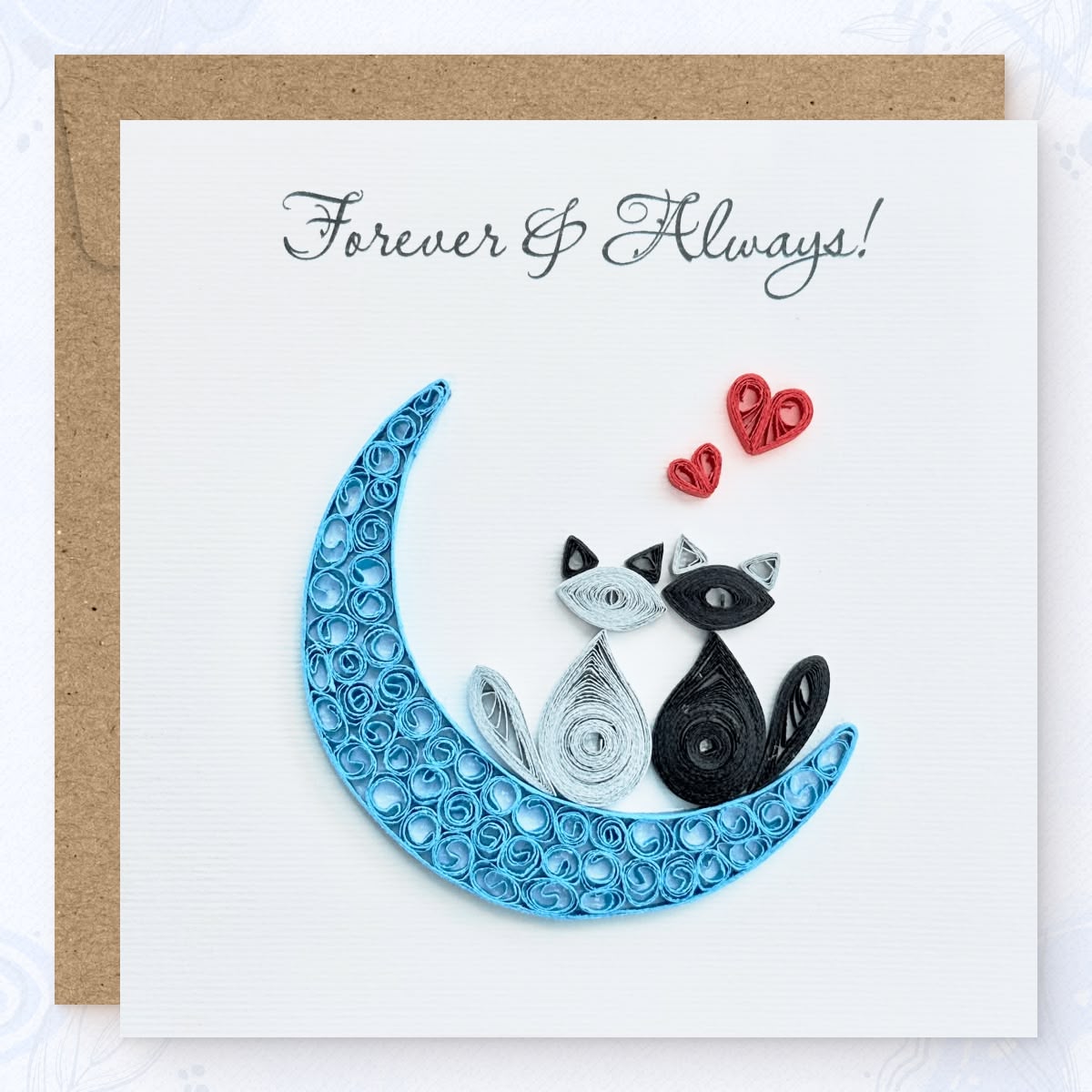 Handmade quilled anniversary greeting card, two cats (one gray, one black) sitting on a blue crescent moon with two red hearts above and "Forever & Always" printed in calligraphic script, paper art by Vonderly
