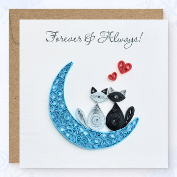 Handmade quilled anniversary greeting card, two cats (one gray, one black) sitting on a blue crescent moon with two red hearts above and "Forever & Always" printed in calligraphic script, paper art by Vonderly