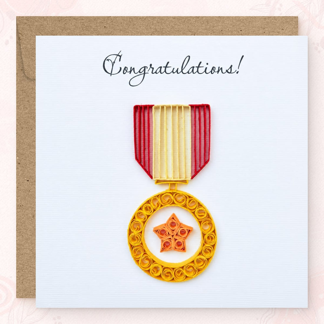 Quilled congratulations card with a gold paper medal, orange star, and a red and cream shield ribbon.