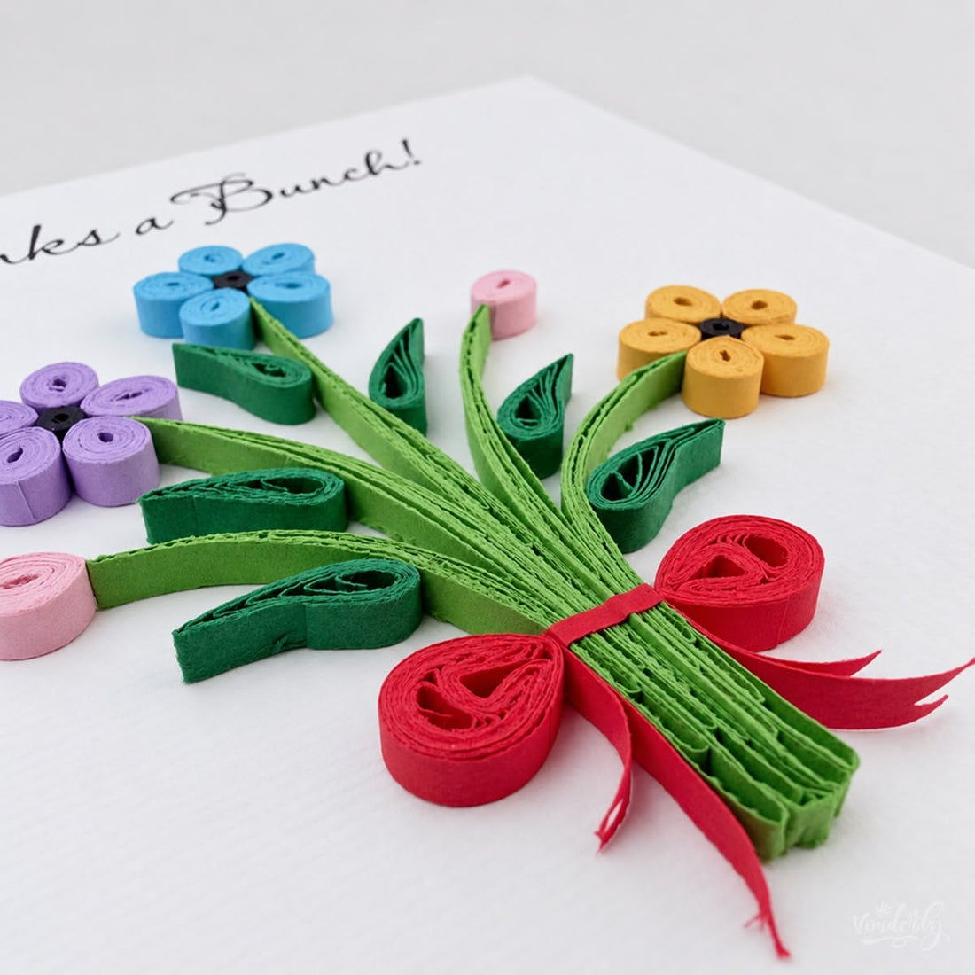 Thank you greeting card with a quilled bouquet in blue, purple, and yellow paper flowers under black script.
