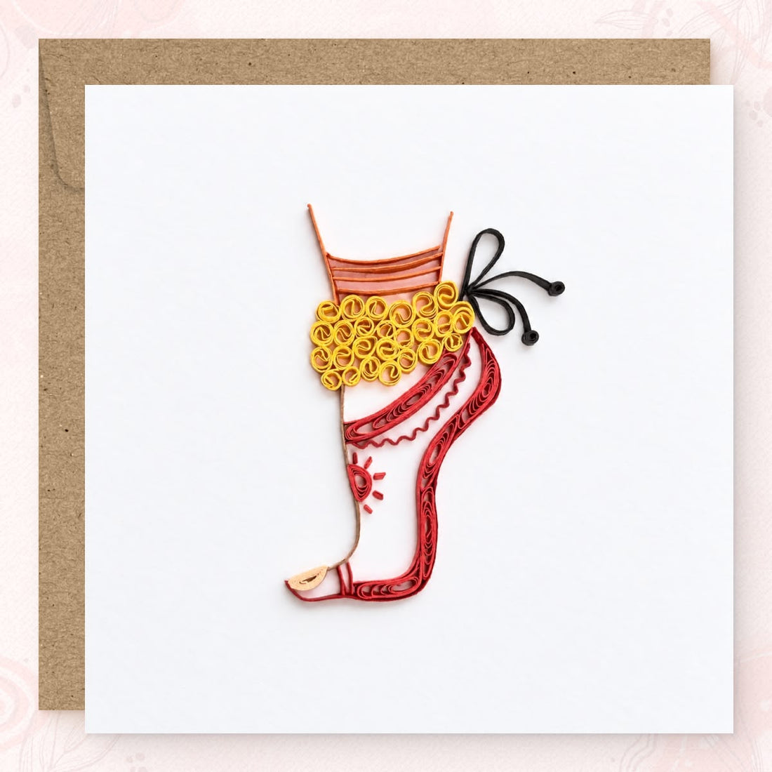 Quilled greeting card showing a Bharatanatyam dancer's leg in red outline with gold salangai at the ankle.