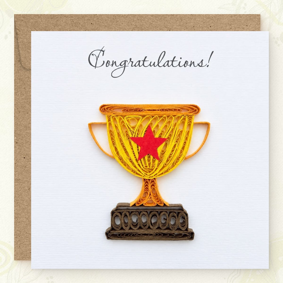 Quilled congratulations card with a gold paper trophy, red star, and brown base.