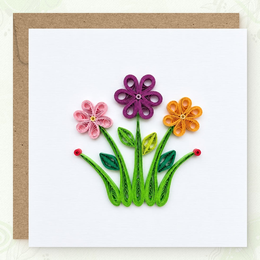 Wildflowers quilled greeting card with pink, purple, and yellow looped-petal flowers above green grass blades.
